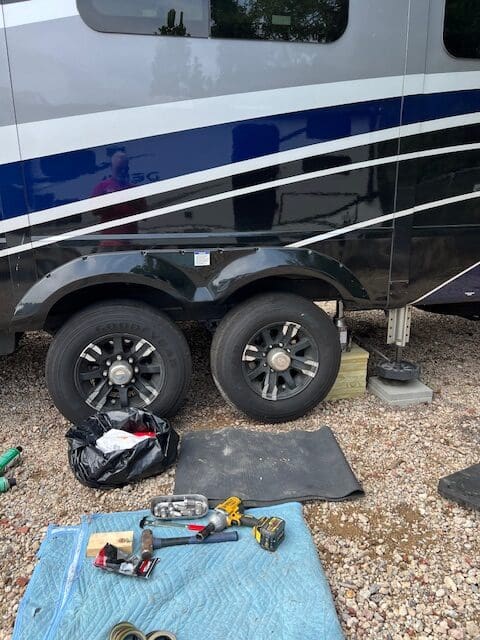 A black and white rv with tire covers on the side.