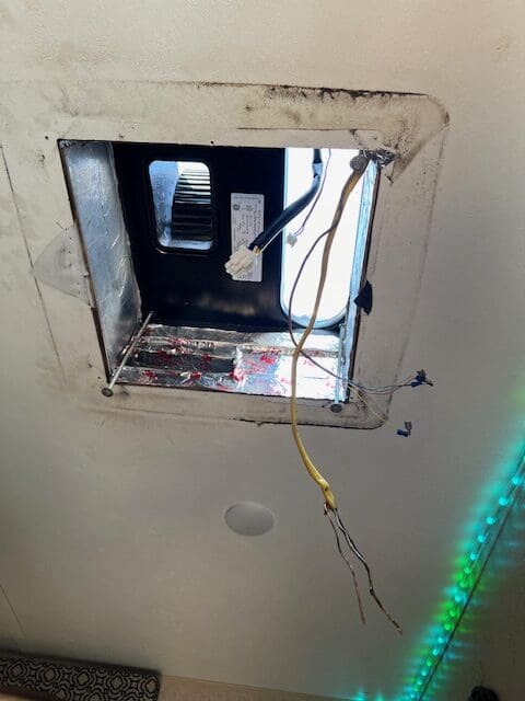 A hole in the ceiling of an electrical box.