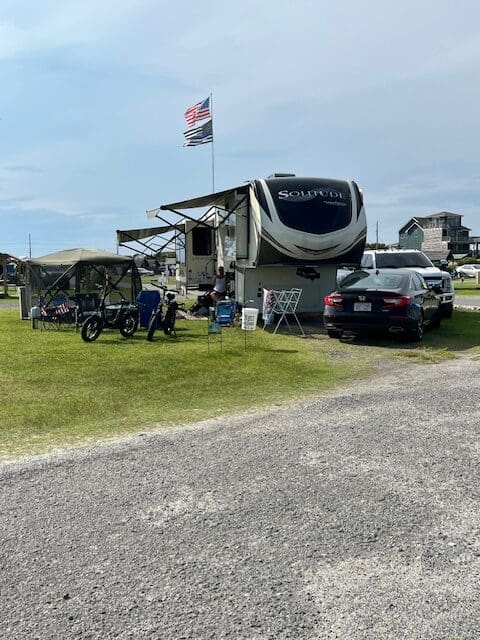 A group of people standing around a parked rv.