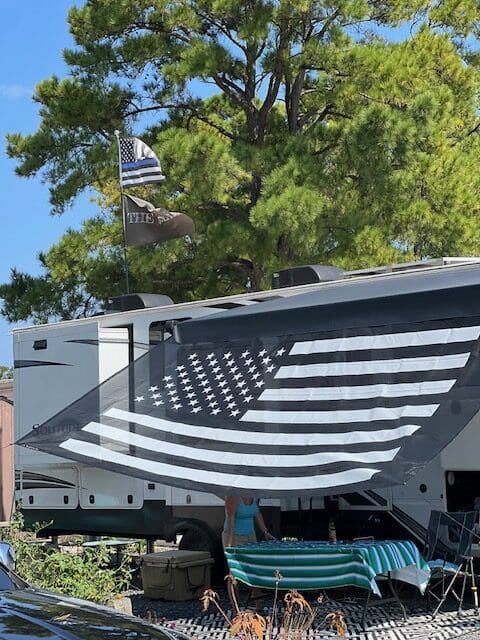 A large american flag is hanging on the side of a building.