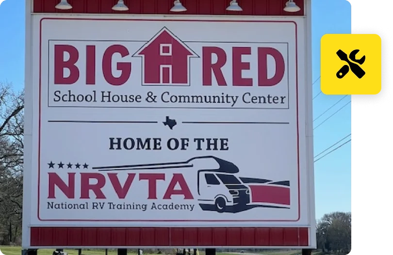 A big red school house and community center sign.